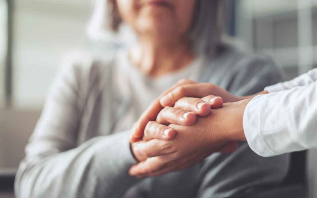 Hands holding old woman's hands
